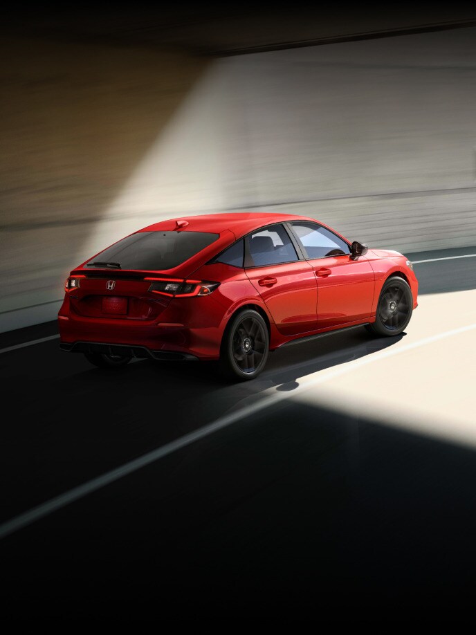 2027 Honda Civic Hatchback Sport in Rallye Red profile driving on tunel (Compact Hatchback).