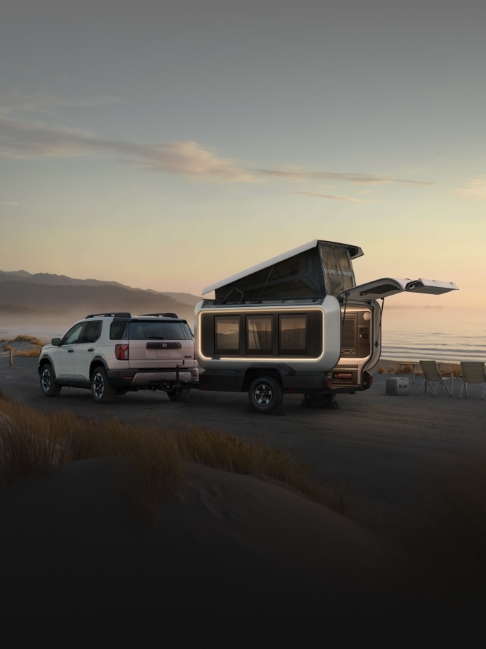 2026 Honda Base Station back on a sandy beach with dunes and ocean at sunset.