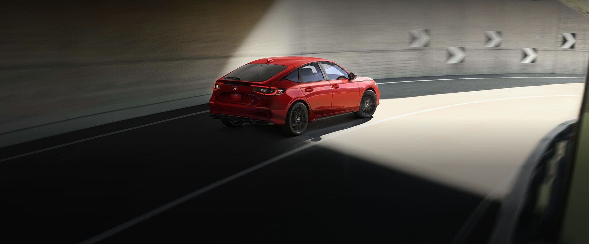 2026 Honda Civic Hatchback Sport in Rallye Red coming out of a tunnel