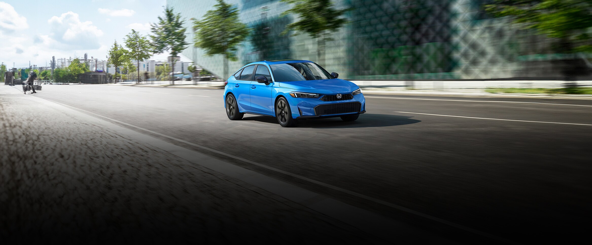 2027 Honda Civic Hatchback Sport Touring Hybrid in Boost Blue Pearl front driving on a city street (Compact Hatchback).