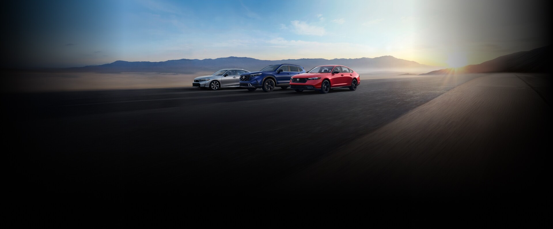 2026 Honda hybrid profile parked on a desert road with mountains in the background.