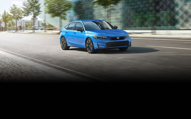 2027 Honda Civic Hatchback Sport Touring Hybrid in Boost Blue Pearl front view driving on a city street (Compact Hatchback).