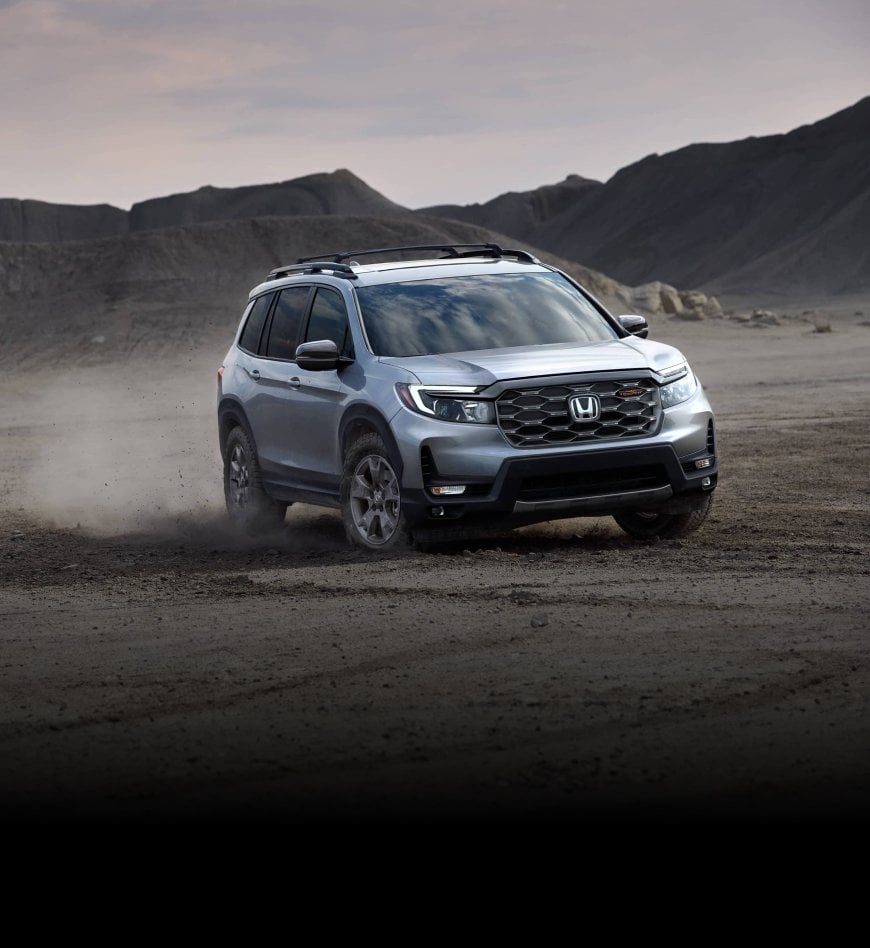 A gray 2024 Honda Passport driving through valley.