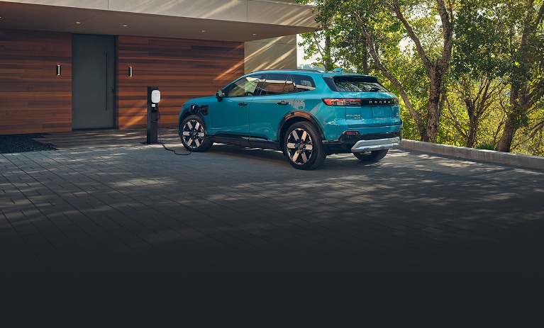 2026 Honda Prologue Elite in North Shore Pearl back charging at a home station in a driveway (All-Electric SUV).