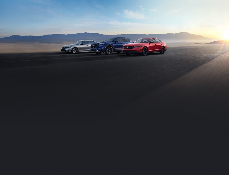 2026 Honda hybrid profile parked on a desert road with mountains in the background.