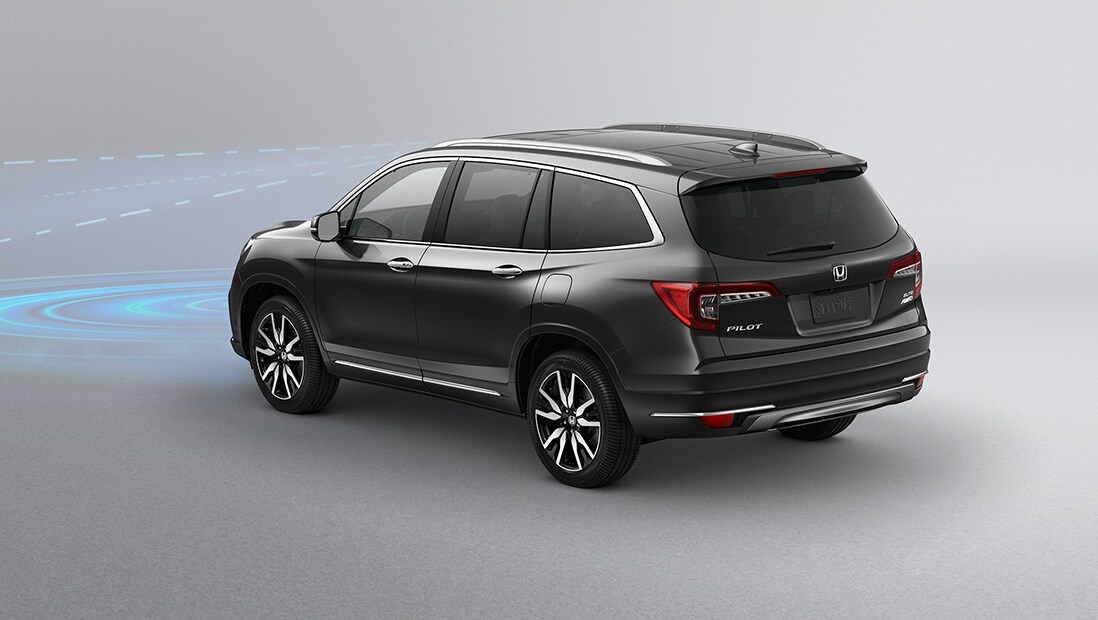 Rear 7/8 driver’s side view of 2020 Honda Pilot Elite in Modern Steel Metallic displaying Collision Mitigation Braking System technology.