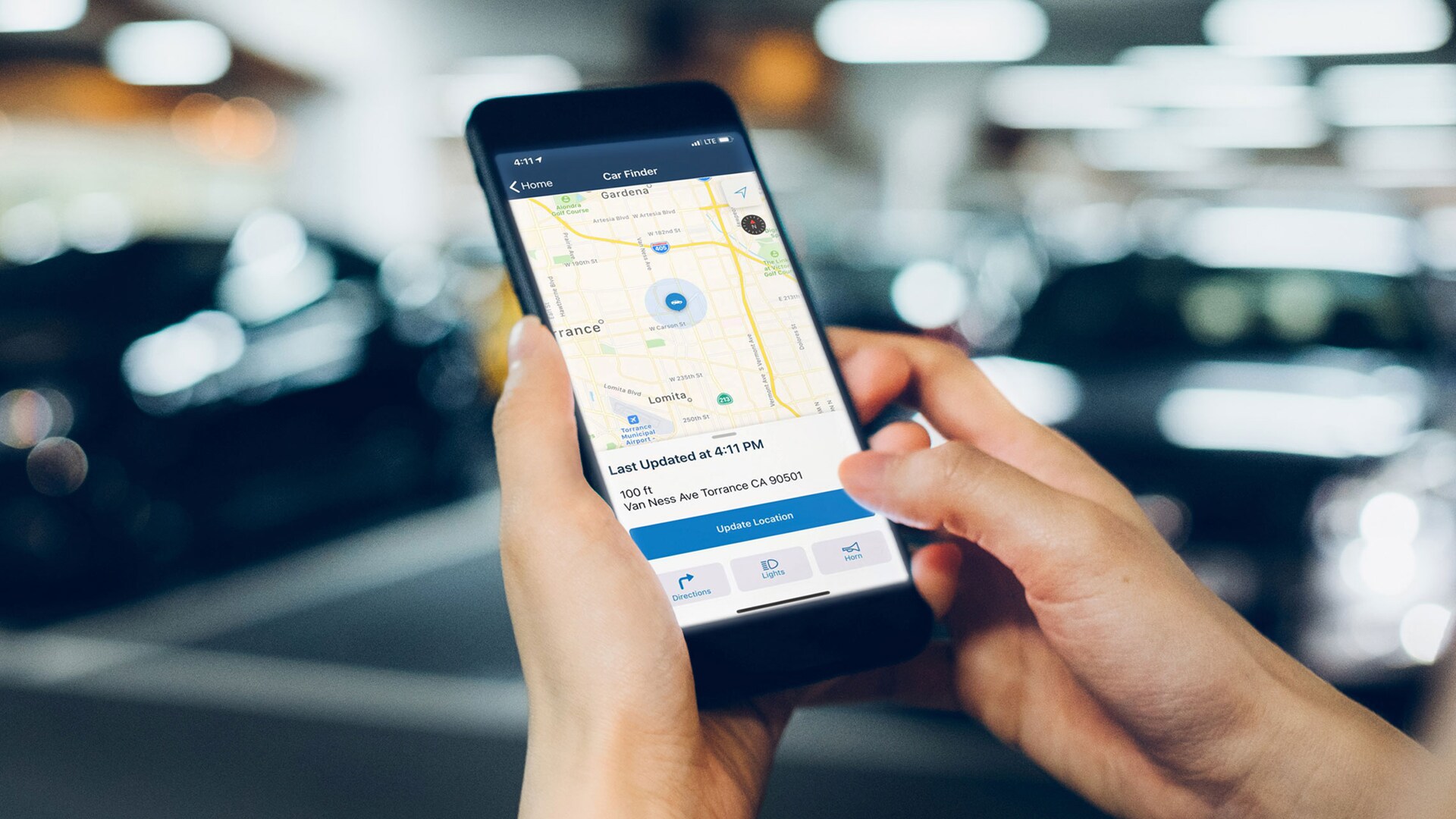 Hands holding a mobile phone displaying a HondaLink® screen.
