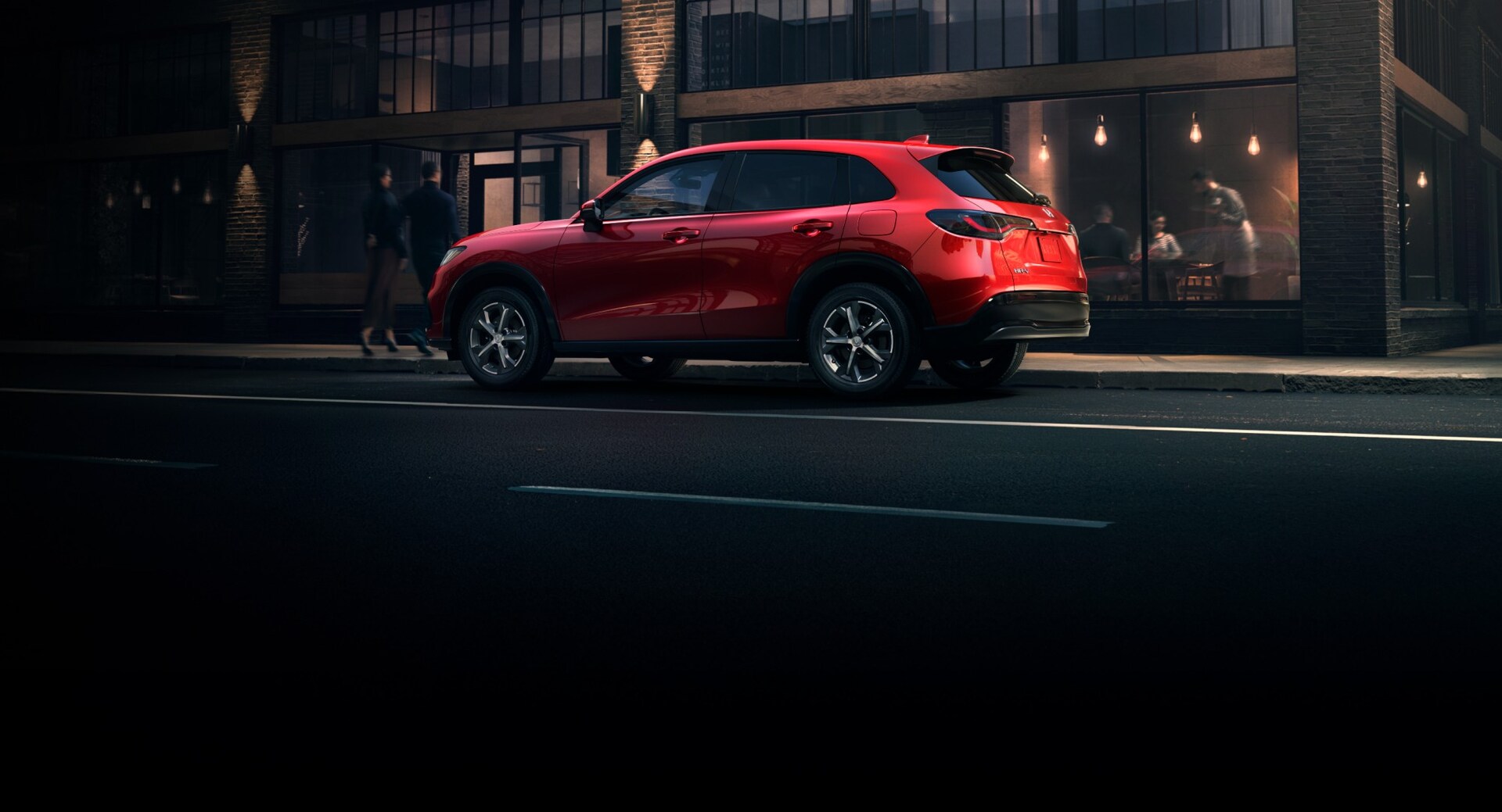 2025 Honda HR-V in Milano Red driving in the city, side view