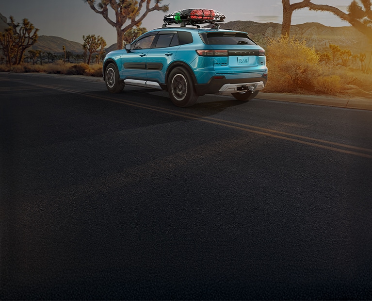 2027 Honda Prologue Touring in North Shore Pearl back driving on a desert road with trees (All-Electric SUV).