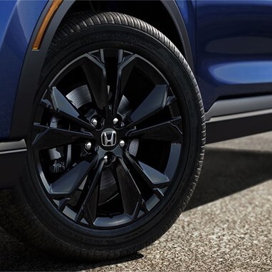 2027 Honda CR-V Sport Touring Hybrid in Canyon River Blue Metallic profile detail of black alloy wheel (Compact Crossover SUV).