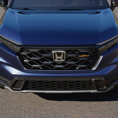 2027 Honda CR-V TrailSport Hybrid in Canyon River Blue Metallic front parked on a paved road outdoors (Compact Crossover SUV).