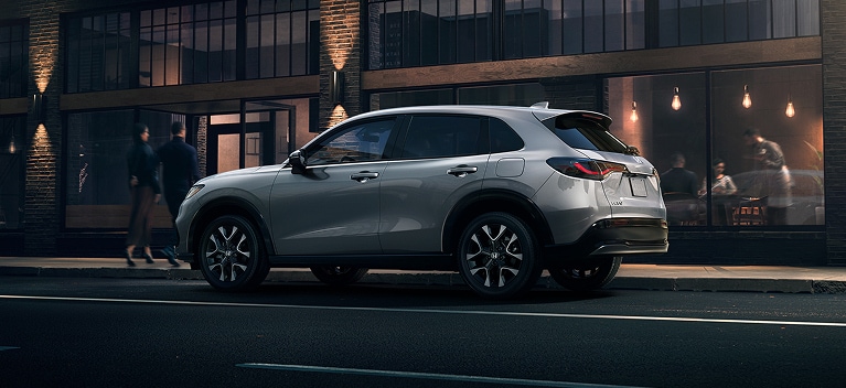 2027 Honda HR-V EX-L in Solar Silver Metallic profile parked on a city street at night (Subcompact Crossover SUV).