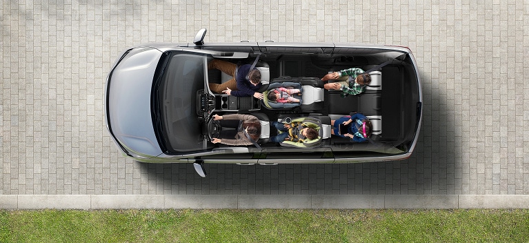 2027 Honda Odyssey Elite in color top on a paved driveway showing the interior seating layout (Minivan).