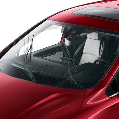 2027 Honda Odyssey Elite in Radiant Red Metallic II front in a studio with rain-sensing windshield wipers (Minivan).