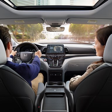 2027 Honda Odyssey Elite dashboard and front seats with driver and passenger looking forward (Minivan).