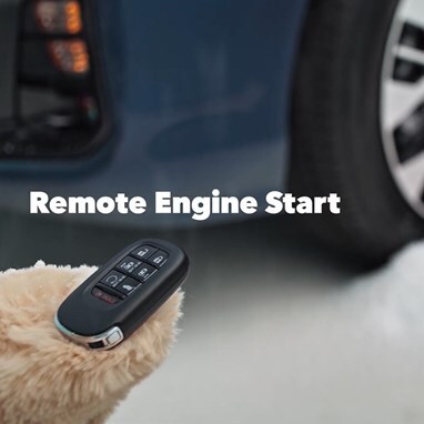 2027 Honda Odyssey Elite detail of the remote engine start key fob held by a person in a winter glove (Minivan).