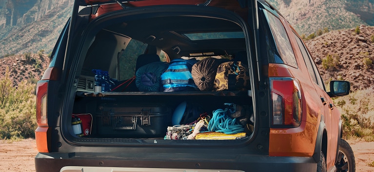 2027 Honda Passport TrailSport Elite cargo area filled with outdoor gear and camping supplies (Mid-Size SUV).
