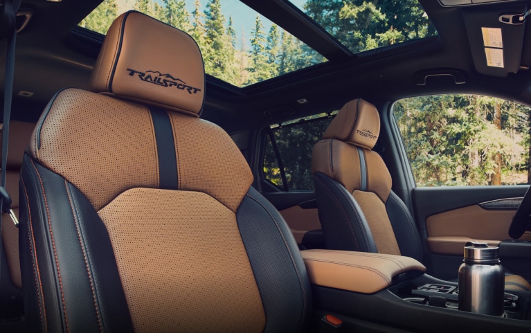 2027 Honda Passport TrailSport Elite Blackout in Radiant Red Metallic front navigating a steep rocky (Mid-Size SUV).