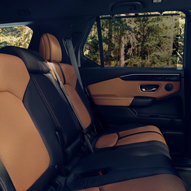 2027 Honda Passport TrailSport Elite featuring brown and black leather rear seats and door panel (Mid-Size SUV).