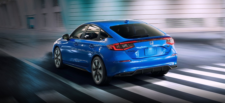 2027 Honda Civic Hatchback Sport Touring Hybrid in Boost Blue Pearl back driving through a tunnel (Compact Hatchback).