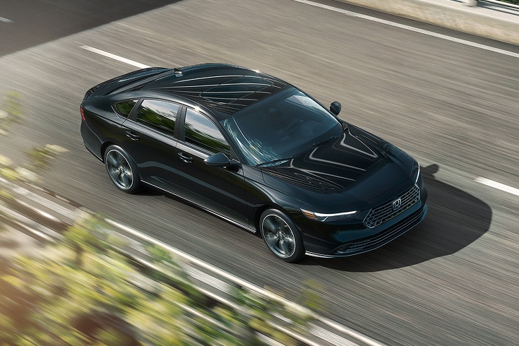 2026 Honda Accord Sport-L Hybrid in Crystal Black Pearl driving along overpass (Mid-Size Sedan).