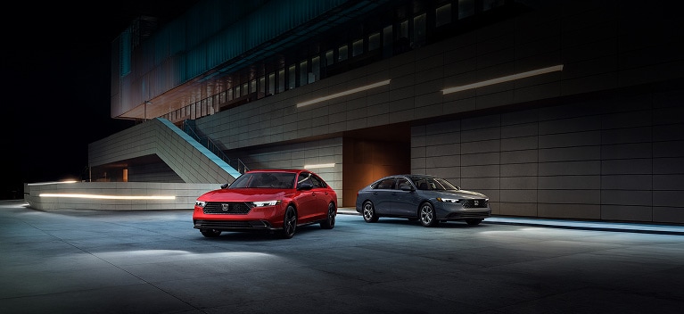 2026 Honda Accord Sport-L Hybrid shown in Radiant Red Metallic and Accord LX shown in Meteorite Gray Metallic (Mid-Size Sedan).