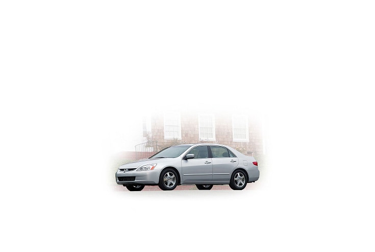 2005 Honda Accord, three-quarter view, with a city in the background.