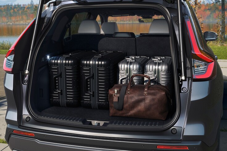 2026 Honda CR-V Sport Touring Hybrid cargo area filled with suitcases and a leather duffel bag (Compact Crossover SUV).