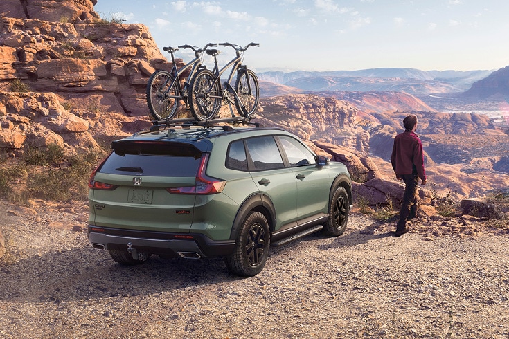 2026 Honda CR-V in Ash Green Metallic back desert canyon with bikes on roof (Compact Crossover SUV). 2026 Honda CR-V in Ash Green Metallic back desert canyon with bikes on roof (Compact Crossover SUV).