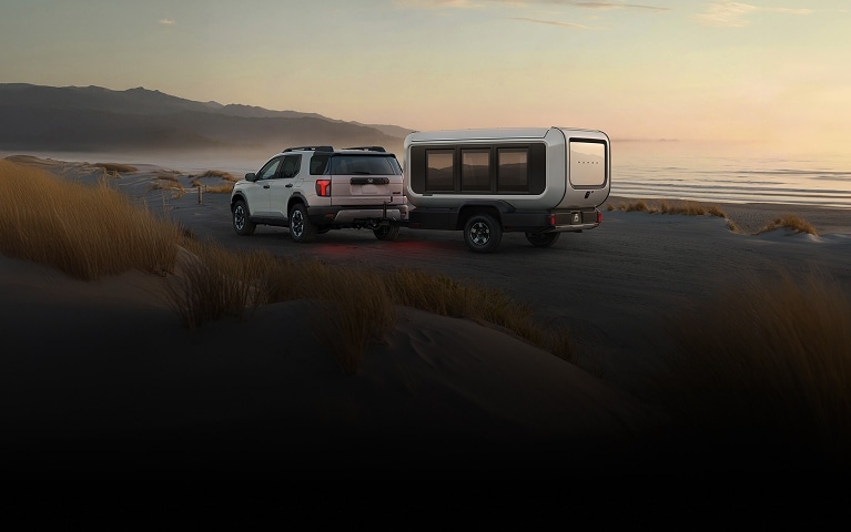 2026 Honda Base Station back on a sandy beach with dunes and ocean at sunset.